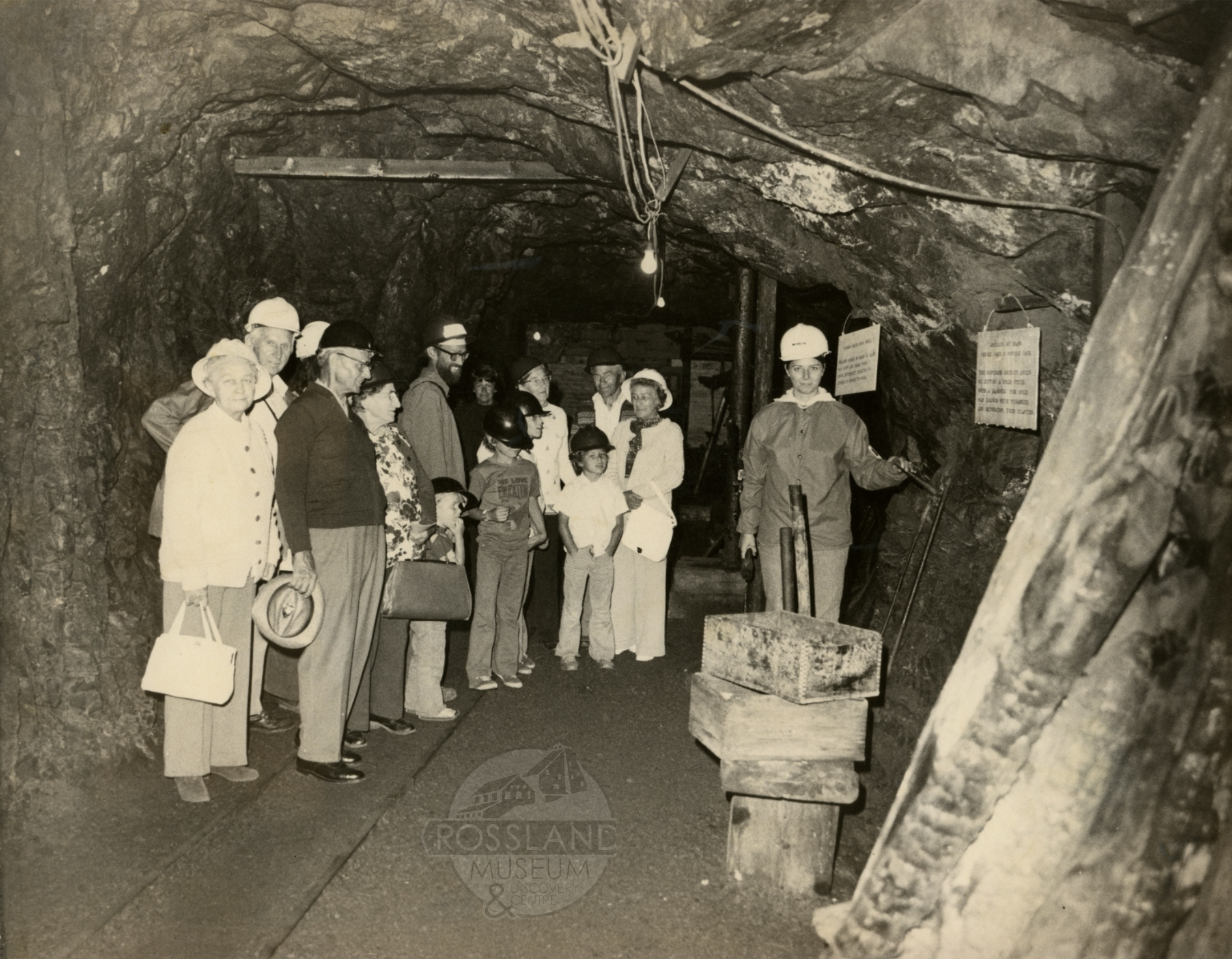 Photo 2276.0246 Underground mine tour, date unknown. Tour guide on right demonstrating the single-jack method of hand drilling