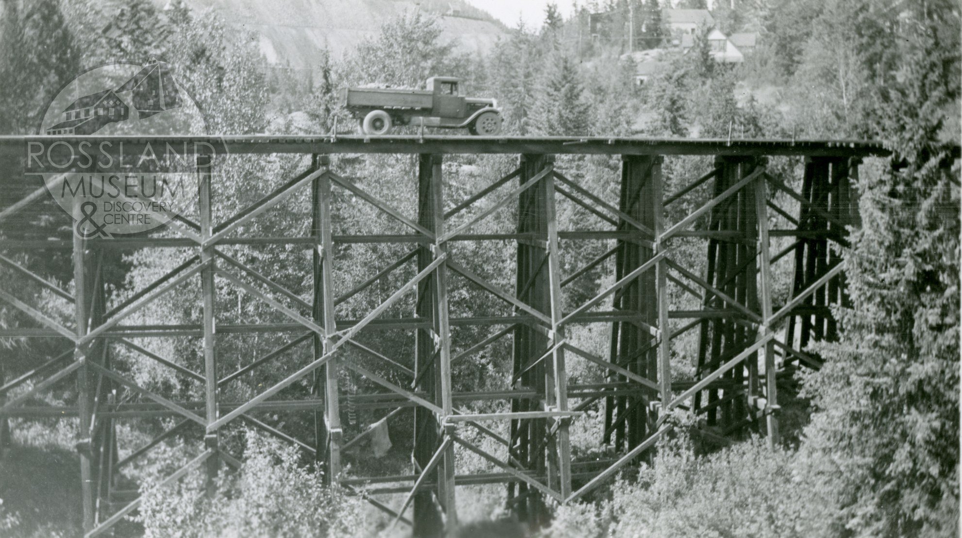 Did you know that Rossland's railways often utilized trestle bridges like this one? Wooden trestle bridges would be built on-site from locally-sourced materials to connect railroad routes over gaps or creeks. In this photo from the McDonald family co
