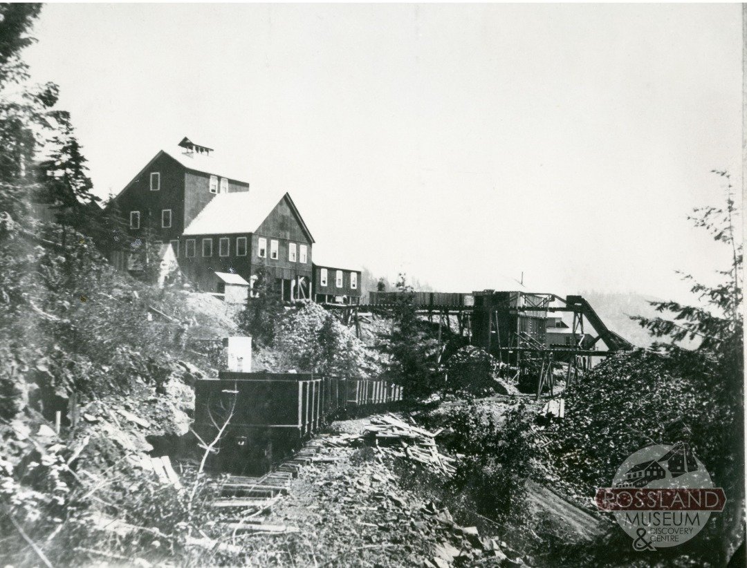 The image that we shared a few weeks ago of the Le Roi Mine Headframe (circa 1904) is how the mine is represented in the majority of our photos of it. Luckily, we do have a few that showcase the mine in the beginning, before it got its signature look