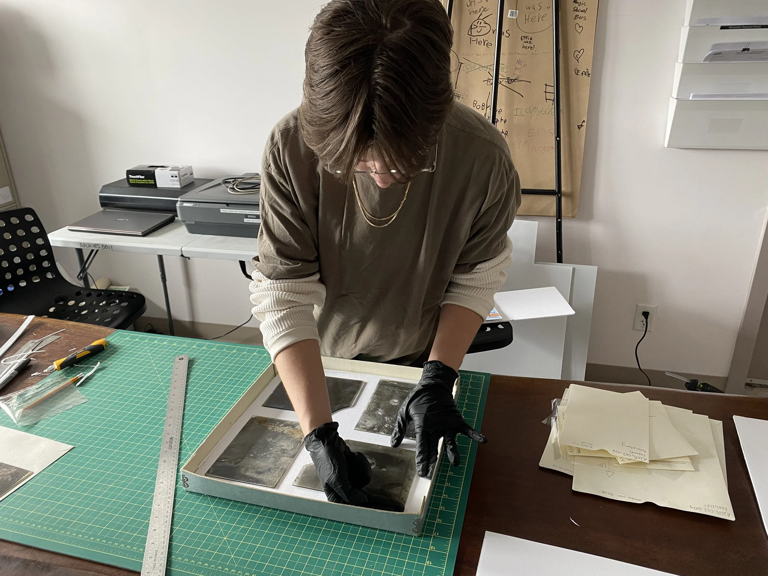 Archives Coordinator Gwen Friesen laying out the glass plate negatives to test how many negatives will fit on a layer