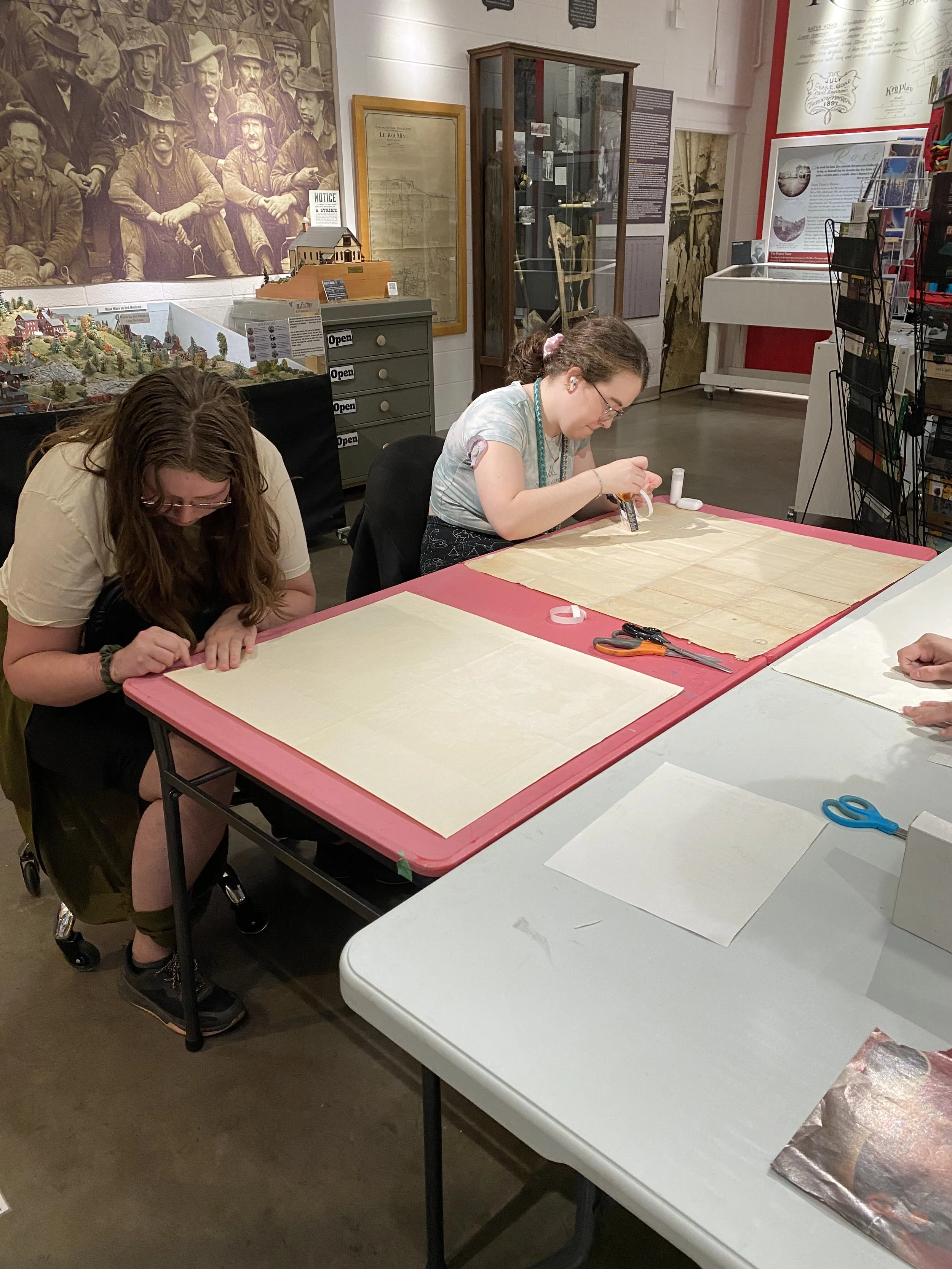 Brenna (right) repairing a map during a student workshop