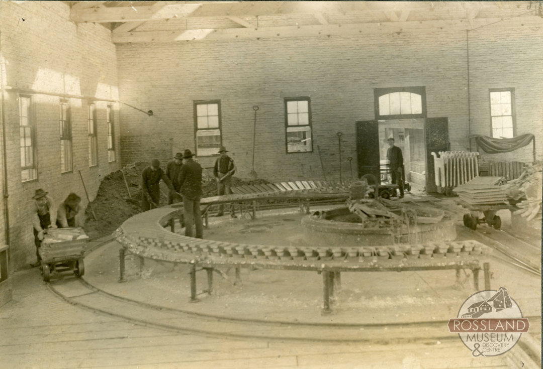 Sepia-toned photograph of workers inside of an industrial building