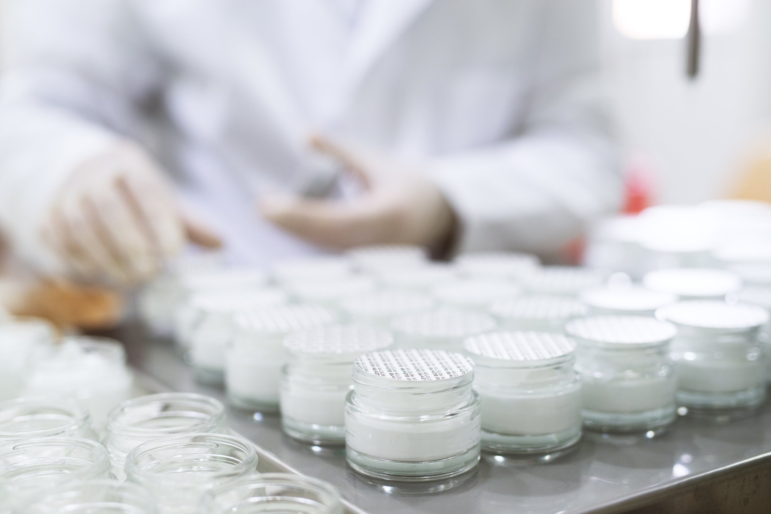 Close up picture of packing a face cream in bottles.