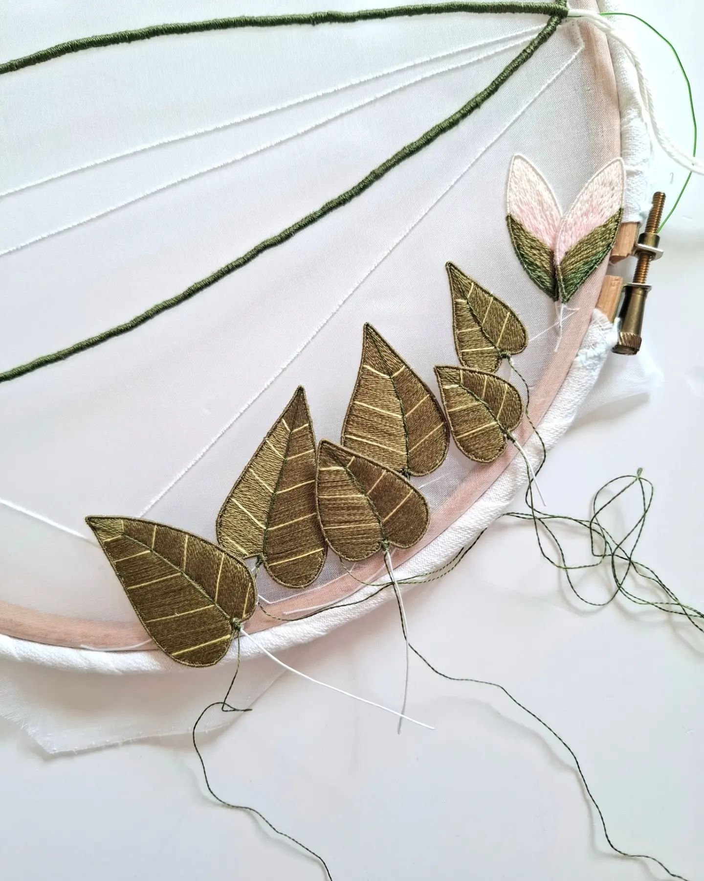 Leaves in a line 🌿 

Day 10 of @seam_collective #SeptTextileLove24 

These leaves are growing up the tails of the firecrest's bow and are loosely based on magnolias. 

I've created them as wired slips, filled with lots of lines of satin stitch and a