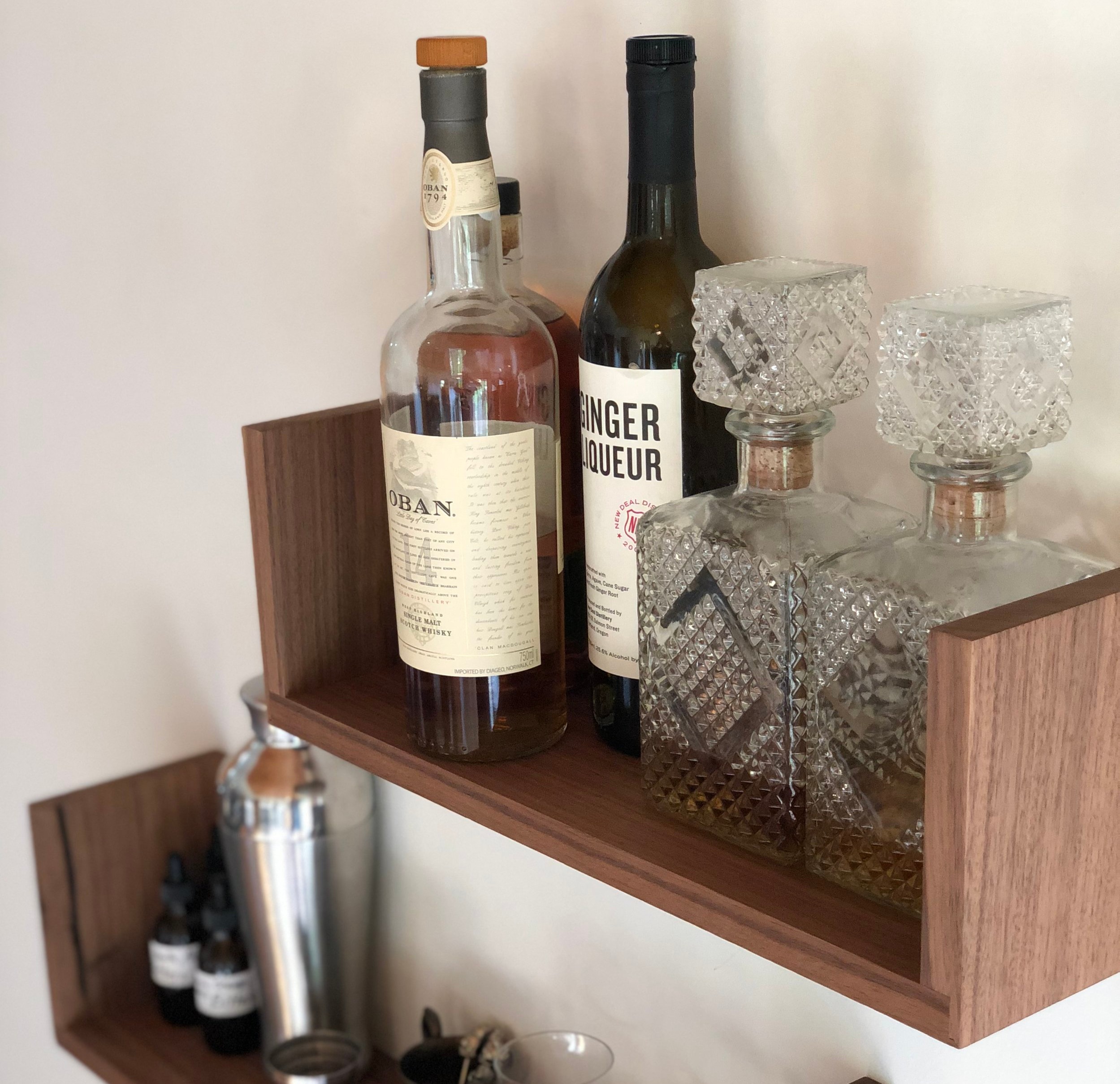 Some Indoor Season home bar essentials displayed on walnut Floating U Shelves