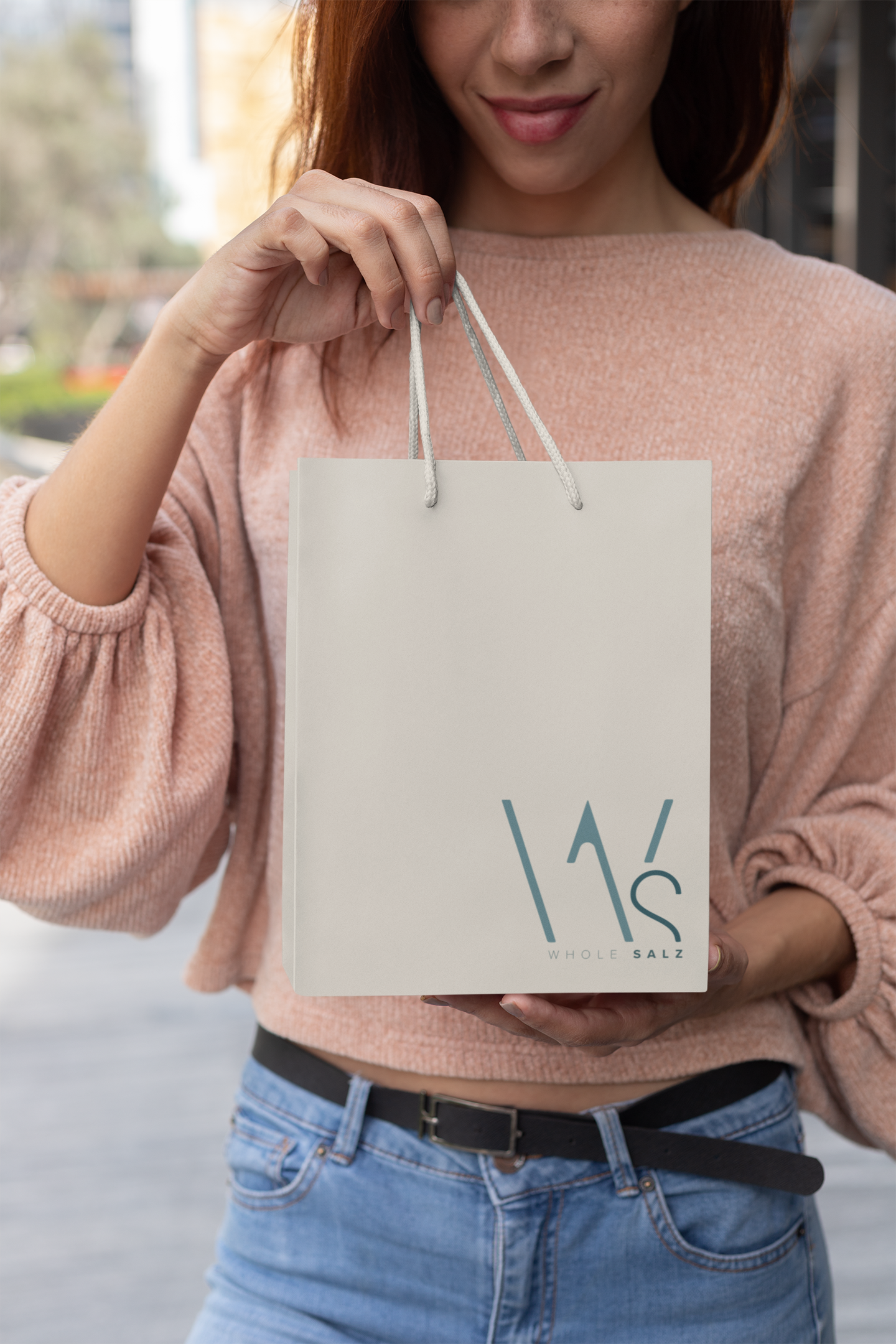 mockup-of-a-young-woman-holding-up-her-small-gift-bag-24046.png
