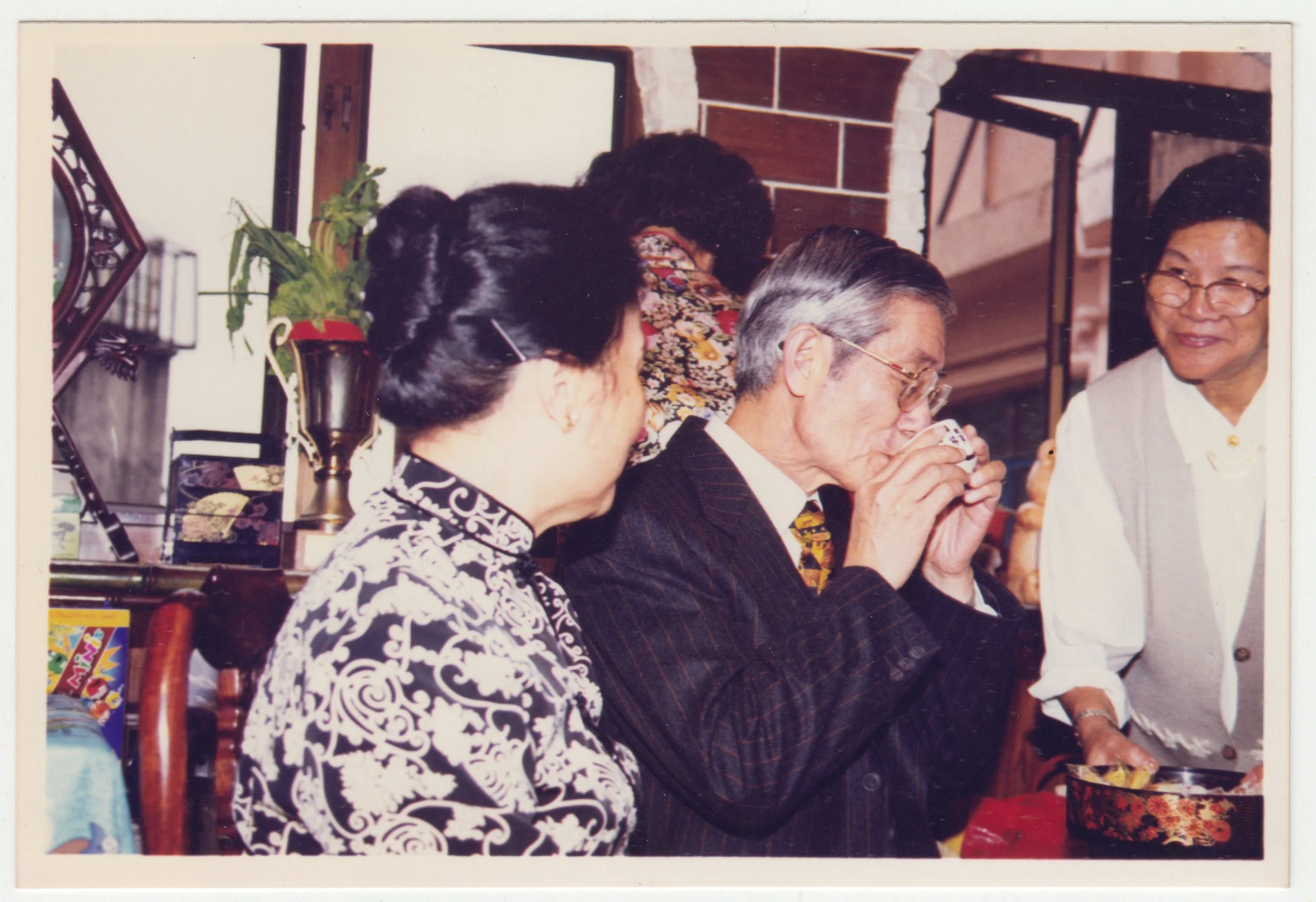 no. 00152 / EE's tea ceremony, taken on 18/F on 22 December 1997. Grandpa drinking tea at EE’s tea ceremony, with Grandma and Mi Por beside him.