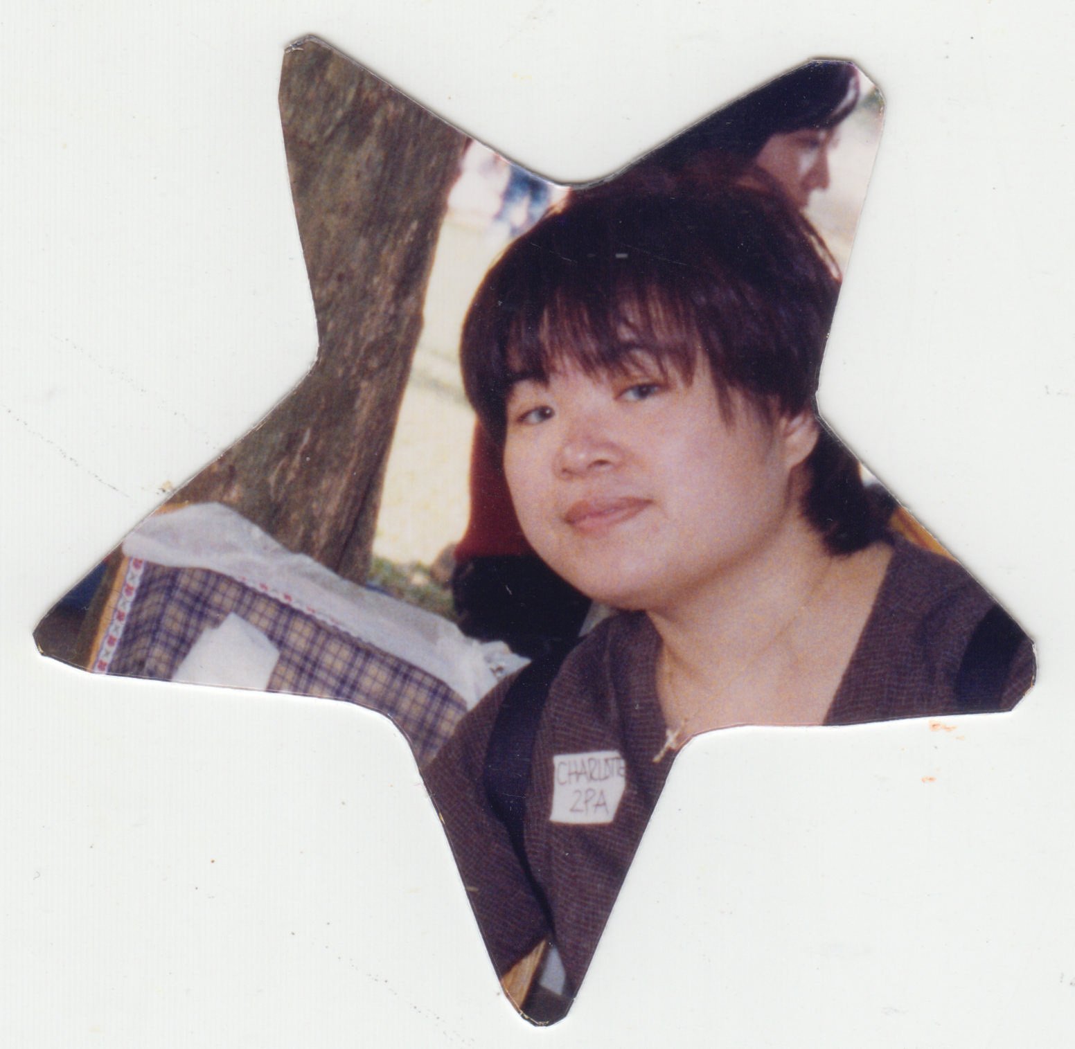 Mum during Kingston International School field trip, c. 2002. A star-shaped cut-out photograph of mum during a school fieldtrip in 2002. This was originally cut out to fit a double frame. The frame is currently lost.