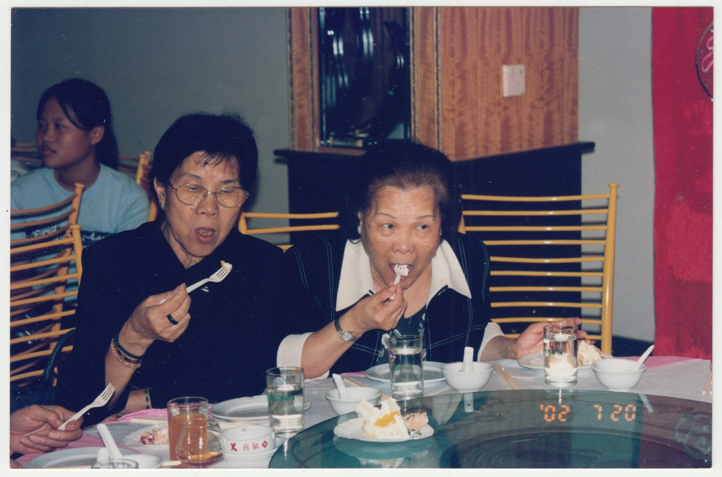 no. 00077 / Grandma & Mi Por at a dinner, taken on 20 July 2002. Behind them is 茜茜表姐, (Granddaughter of 三舅公)