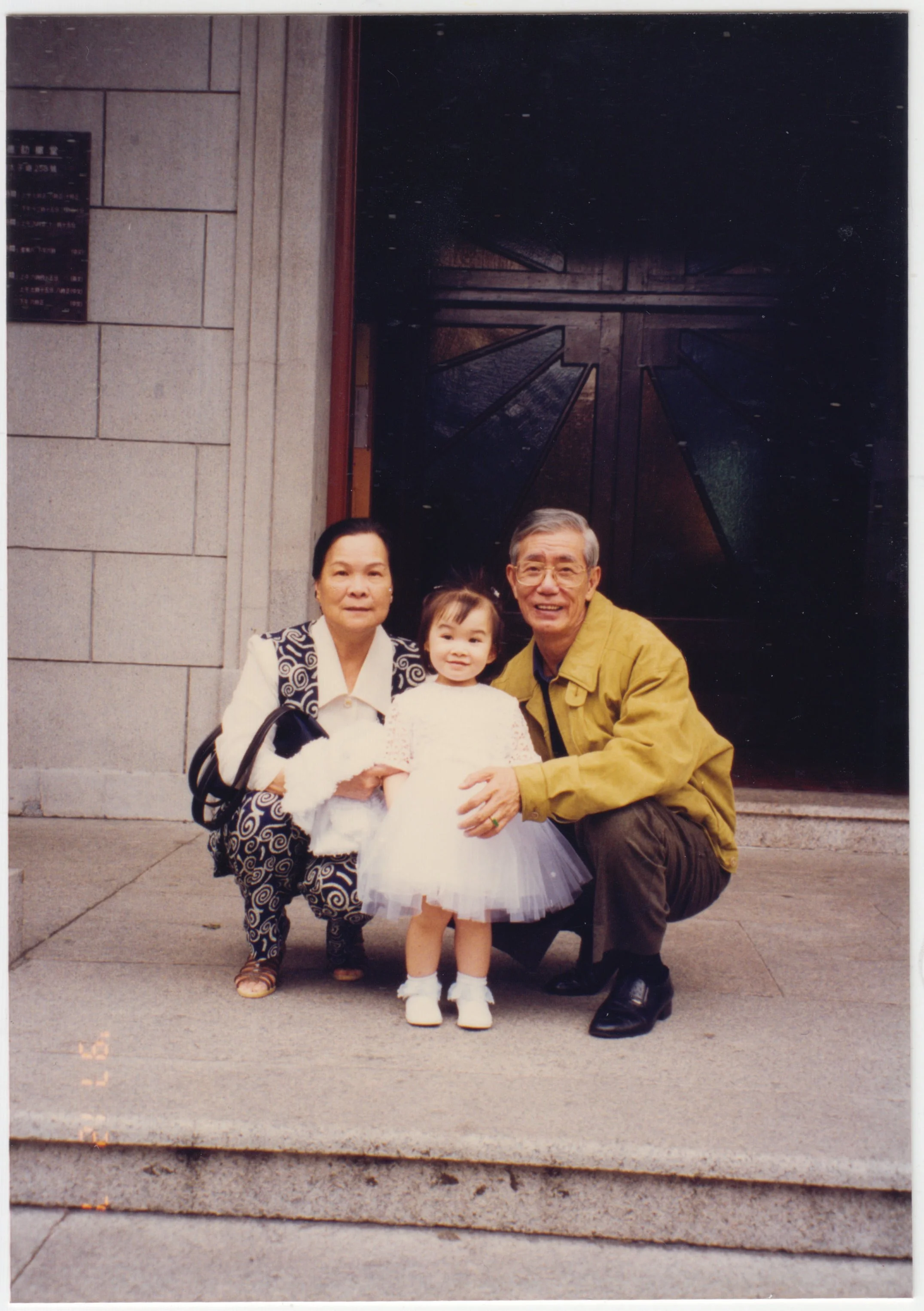 Grandparents & Charlotte outside unidentified church after Charlotte's Catholic Baptism, 7 December 1997.