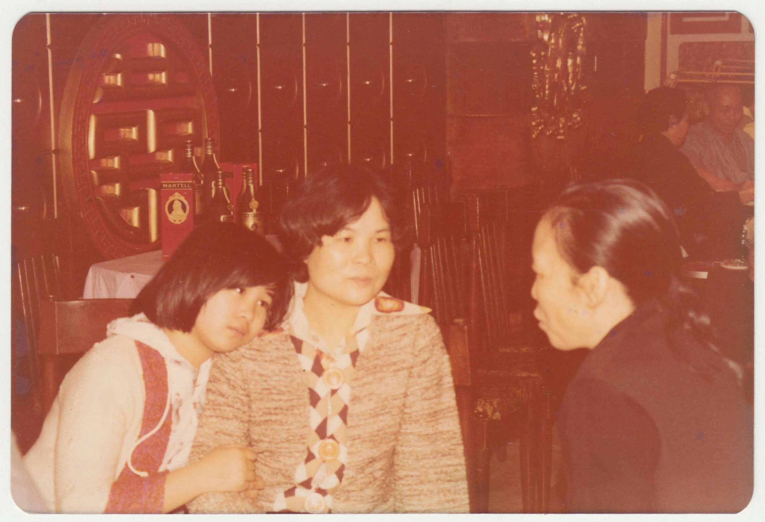 EE leaning on Grandma as she chats to Mi Por’s Brother-in-Law’s wife at a banquet in Hong Kong,  c. 1979-1980