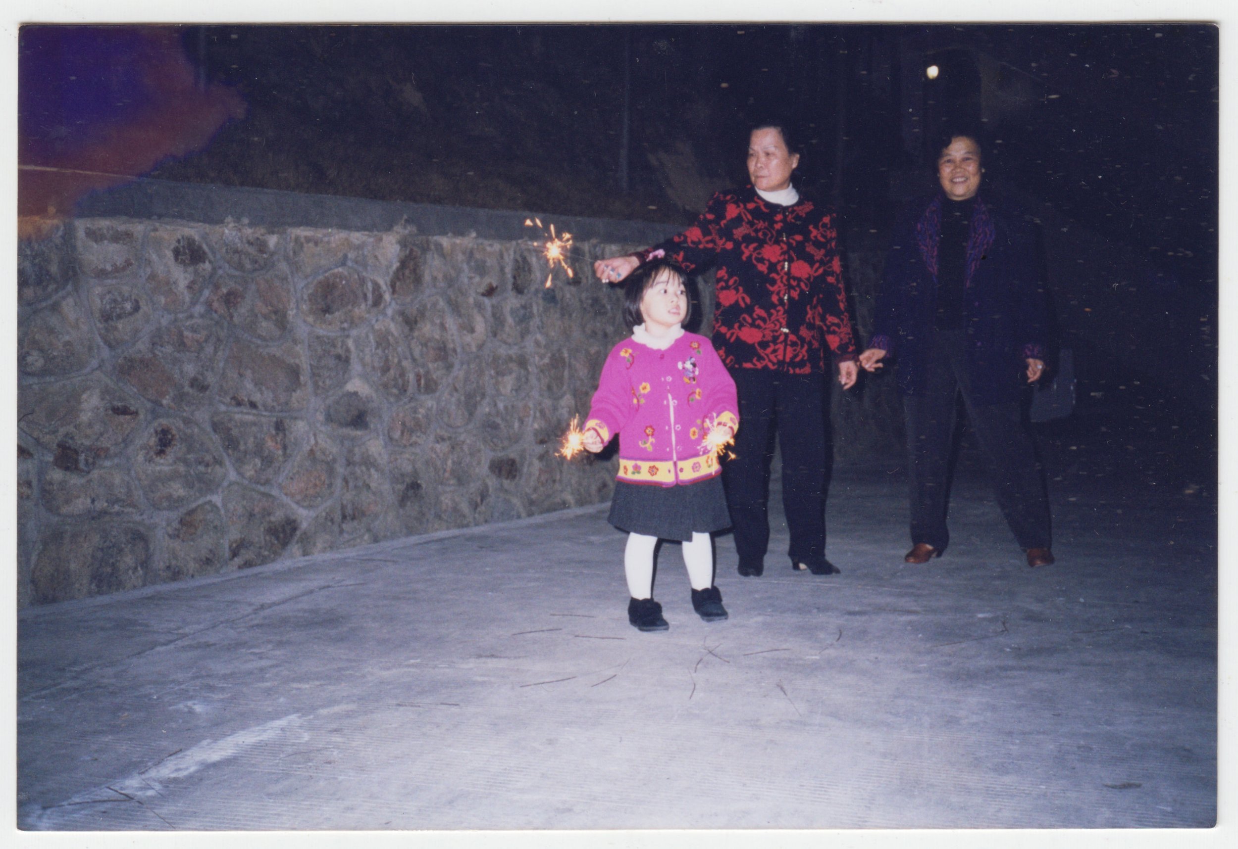 no. 00454 / Grandma, 三襟婆 & Charlotte in Zhongshan playing with sparklers, c. February 2000. This was also probably taken during Chinese New Year, when the grandparents would host a Chinese New Year Banquet at Marble Bra Factory 廣東萬邦公司.