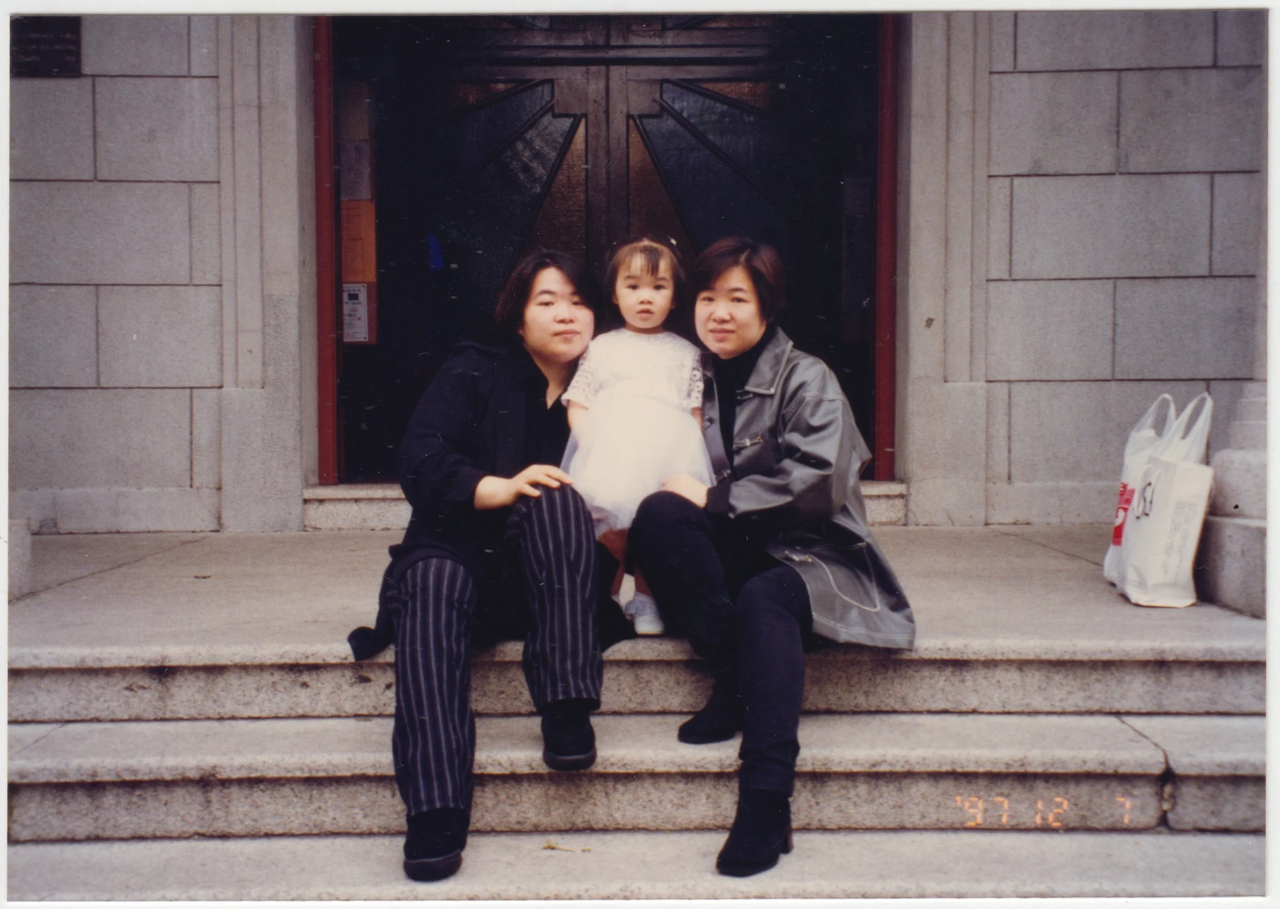 Mum, EE & Charlotte outside unidentified church after Charlotte's Catholic Baptism, 7 December 1997.