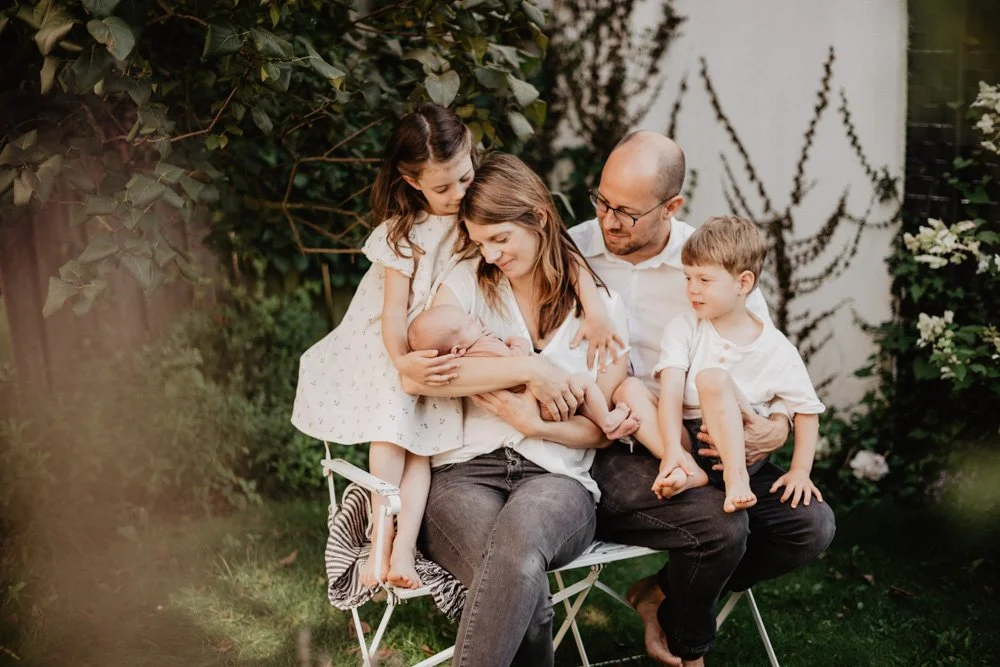 Familienporträt mit Baby auf Gartenbank