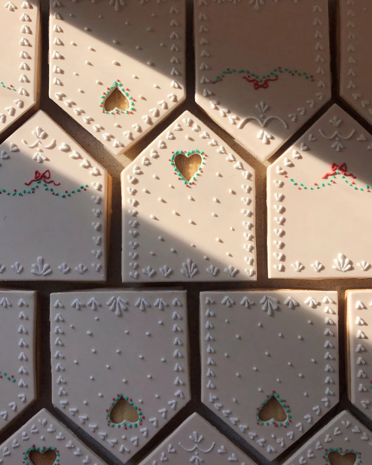  Close-up of hand-piped icing detail on a couture-inspired gingerbread house roof 