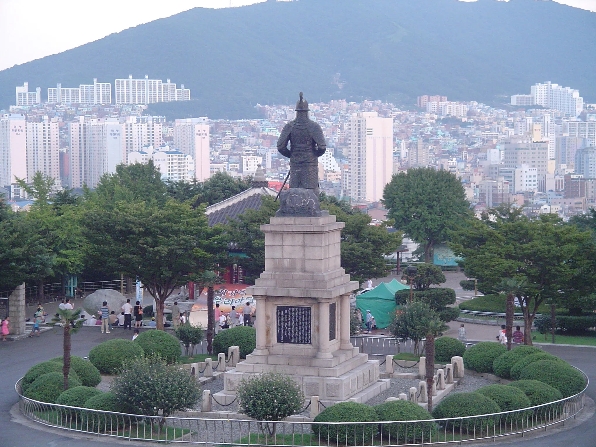 A statue of Admiral I Sunsin in a park atop Busan Tower looks out across the city by day. Photo by Jeff Harr, CC BY-SA 3.0 .
