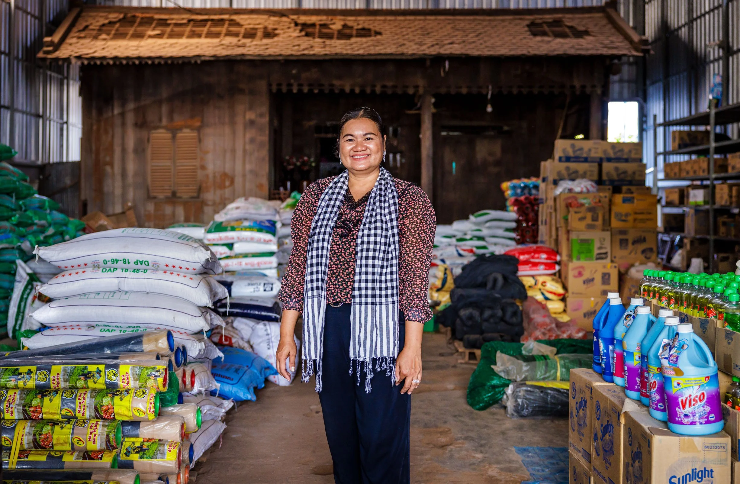  The Enterprise of Agriculture — An environmental portrait of a local agricultural input entrepreneur and farm business advisor, showcasing the micro-retail networks driving smallholder productivity in partnership with iDE Cambodia 