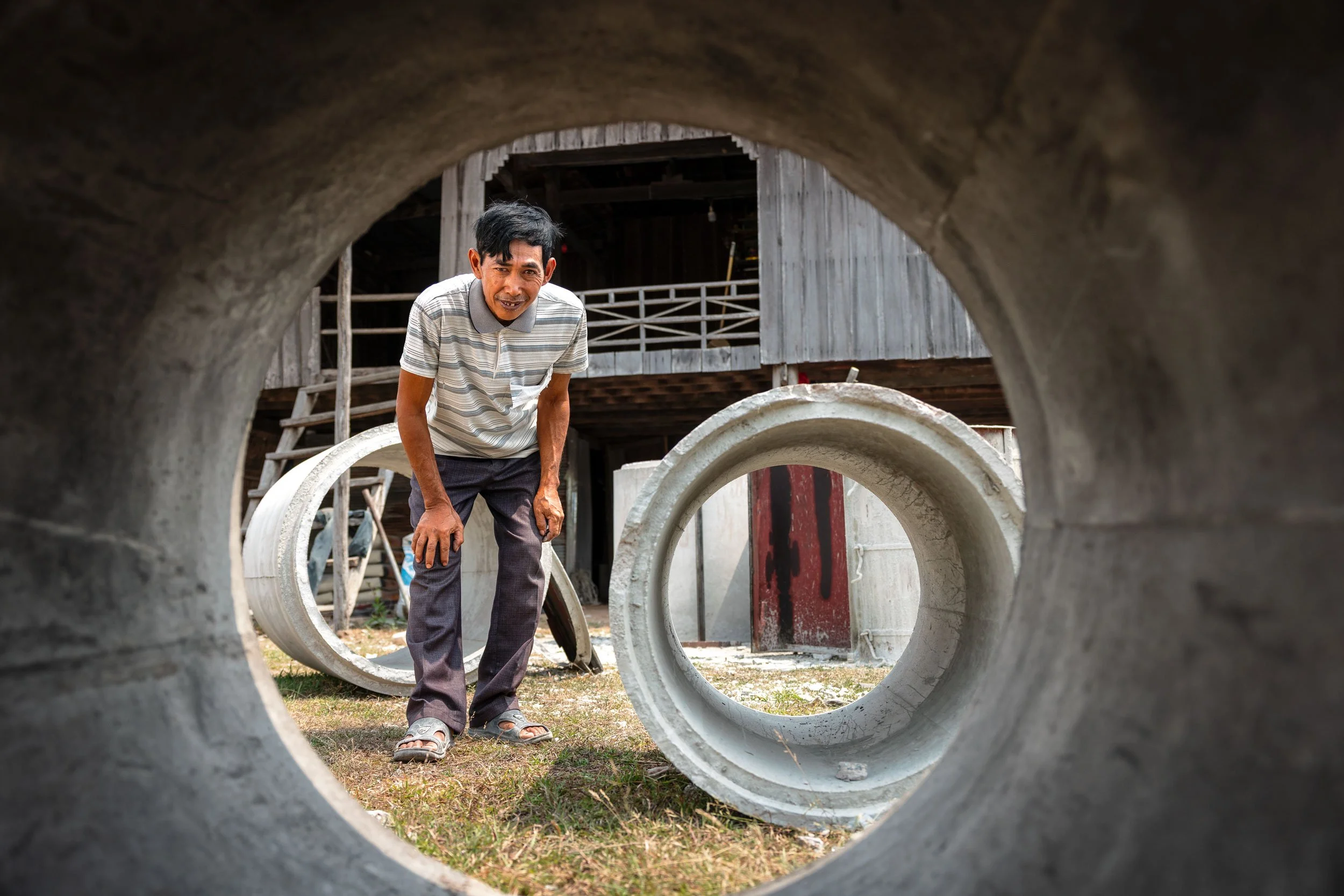  Shaping Infrastructure — A portrait of a local concrete entrepreneur producing latrine rings and sanitation components in Kampong Cham province, highlighting market-driven WASH supply chains with iDE Cambodia. 