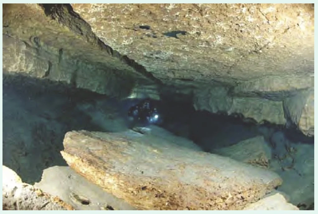 Jacobs Well Spring: Photograph showing the karst enlarged fracture routing groundwater to the surface. If you click on the photo to enlarge, you will be able to see the diver in the center of the photo shining a light. A good reference for the size of the cavern.