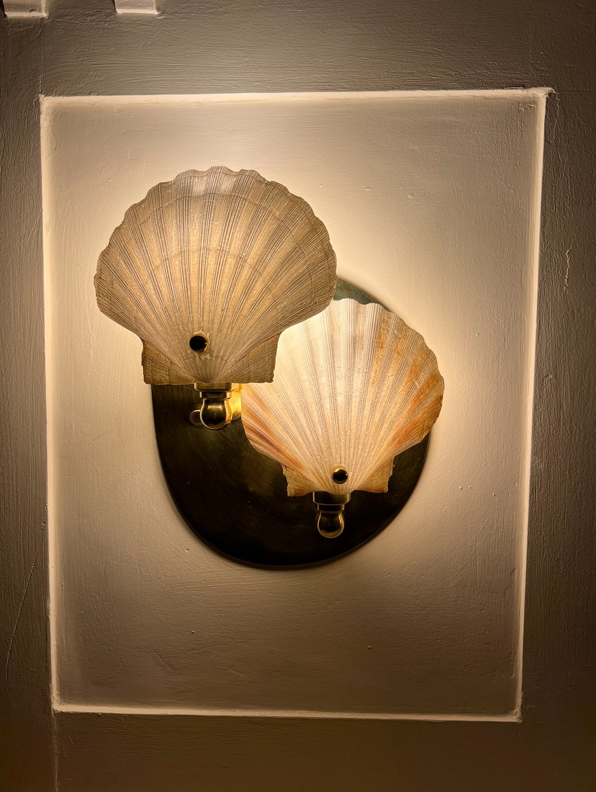 A bespoke wall light in the main hall, one of a pair.