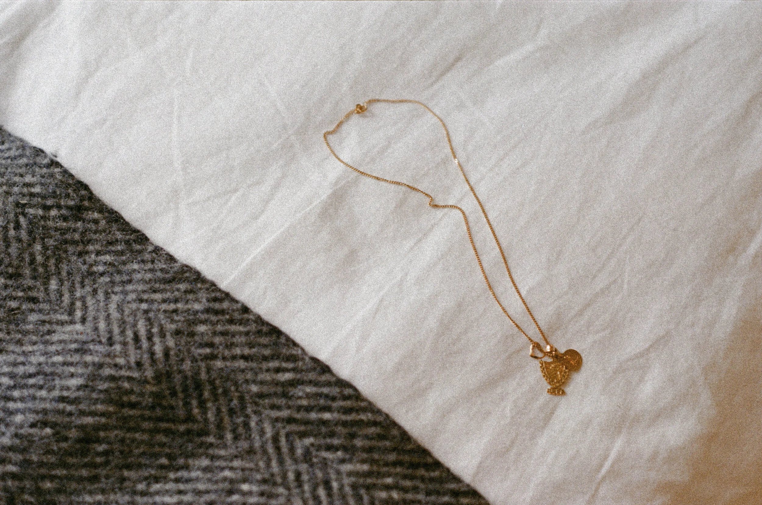 A necklace that consists of three charms—the crest of Cuba, la Vírgen de la Caridad (the patron saint of Cuba) and a delicate heart. Ali and her sister received identical necklaces as a gift from their mother, who also wears one.&nbsp;