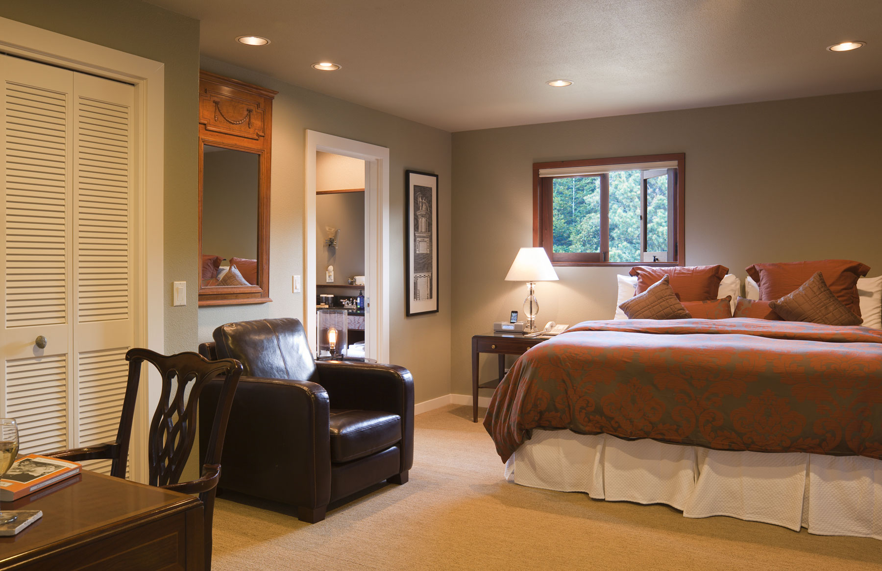 The second room in the Meadowview suite contains a king bed, desk, and leather chair. 