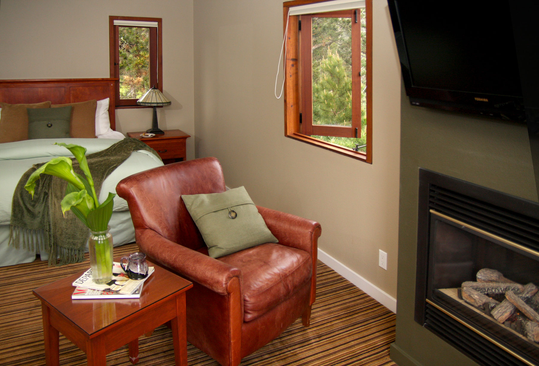 A comfortable leather chair in front of the fireplace in the Osprey room