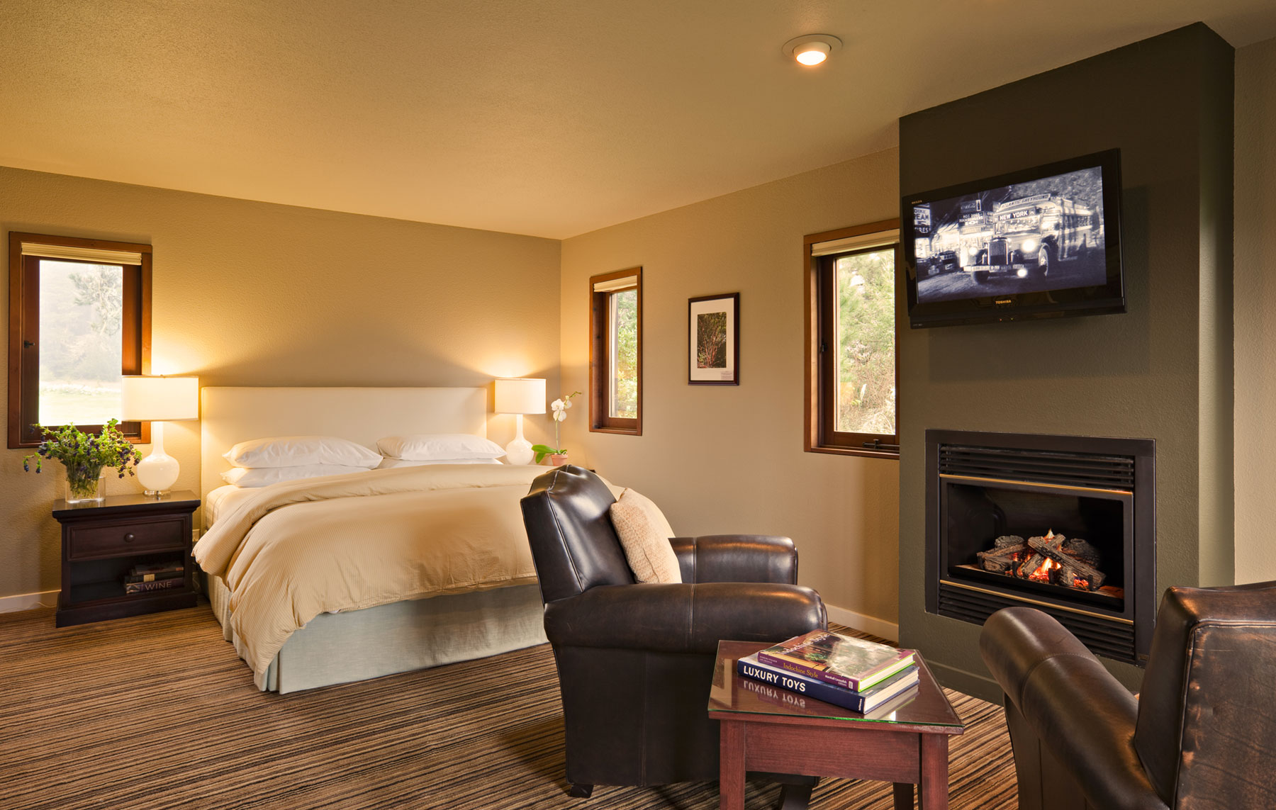 The Manzanita Room with King bed, flat screen TV, and leather armchairs around a fireplace