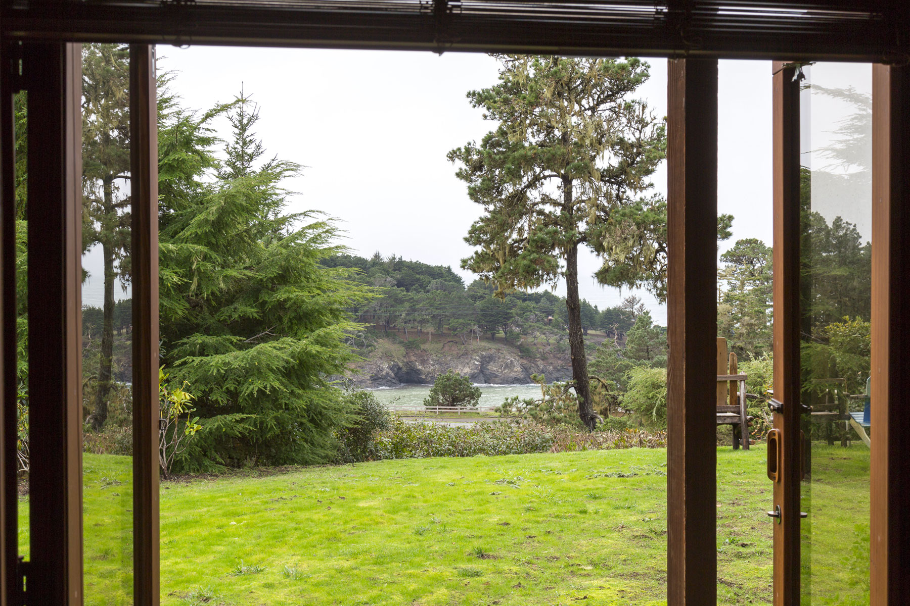 A view out to the lawn and the ocean in the distance from the Manzanita room