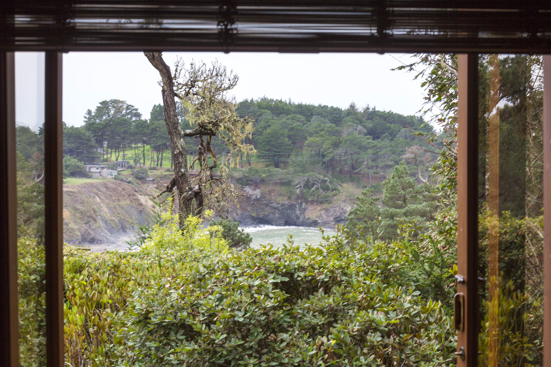 The Madrone room window looks out to a view of the ocean cove