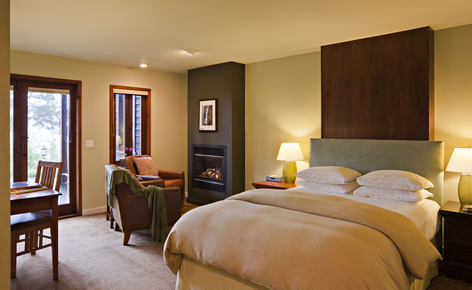 The ADA Accessible Redwood room with Queen bed, desk, French doors, and leather seating around a fireplace