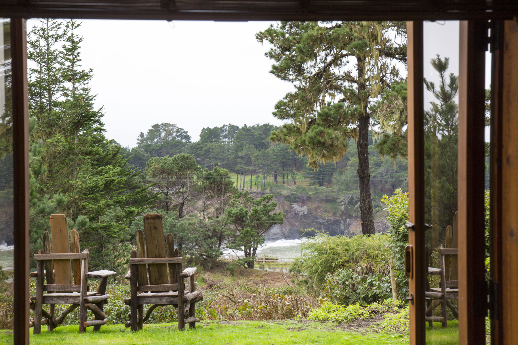 The first floor Redwood room view out to the lawn and the ocean cove beyond.