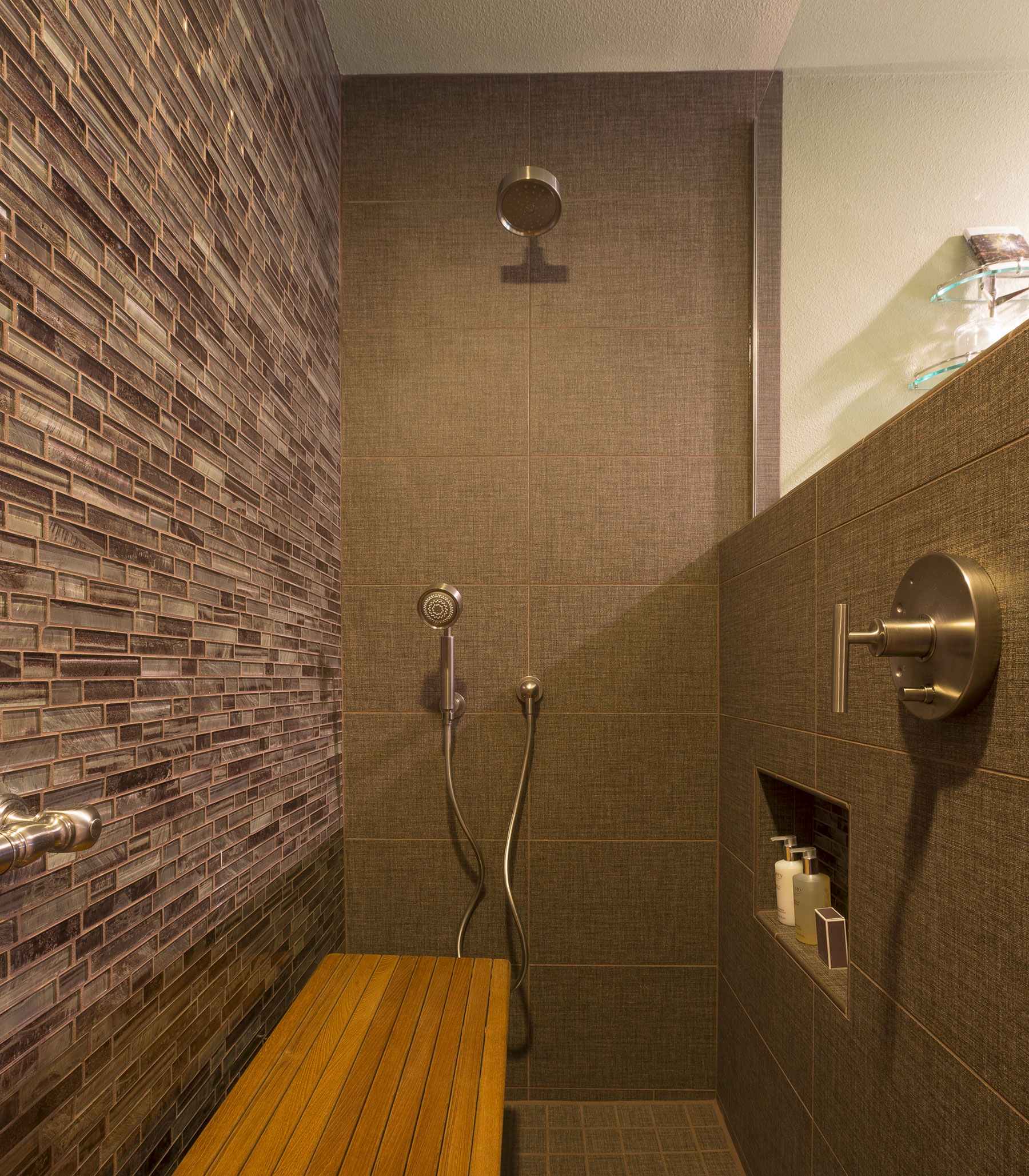 The Redwood room bathroom with support bar and wooden bench, plus both seat and standing height removable shower heads.