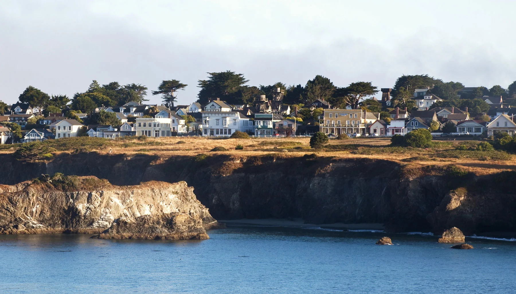 The main street of Mendocino across the water and beyond the headlands.