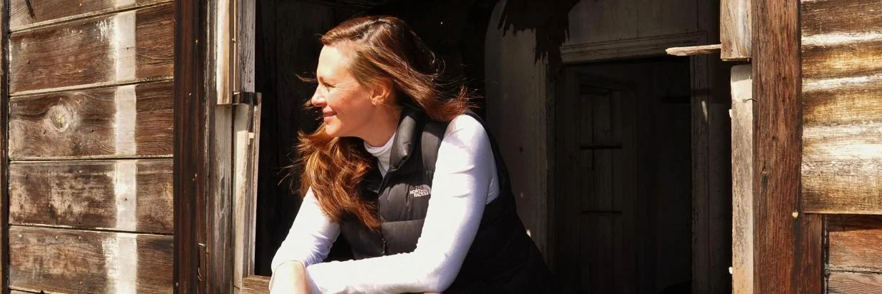 Sarah leans out a window and enjoys the sun.