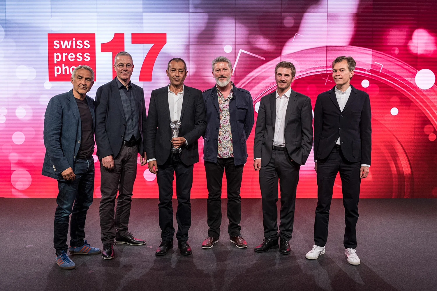 The award-winning photographers pose on the stage, from left to right, Rolf Neeser, Urs Bucher, Zalmai Ahad as Photographer of the Year, Mark Henley, Anthony Anex and Stephan Rappo, on Wednesday, April 26, 2017, at the award ceremony for the Swiss Media Prize Swiss Press Award 17 at the Hotel Bellevue in Bern. (KEYSTONE/Alessandro della Valle)