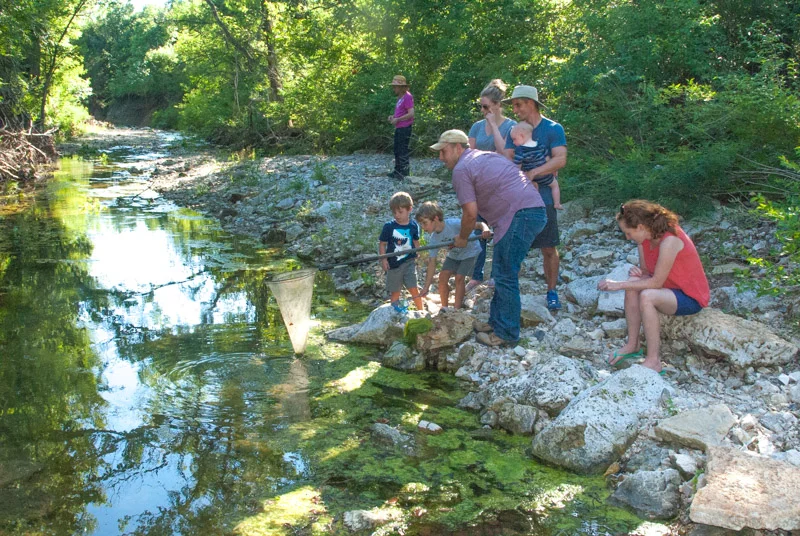 Two families enjoying a stream in the Flint Hills