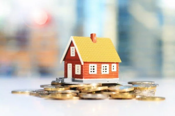 coins in front of a toy house