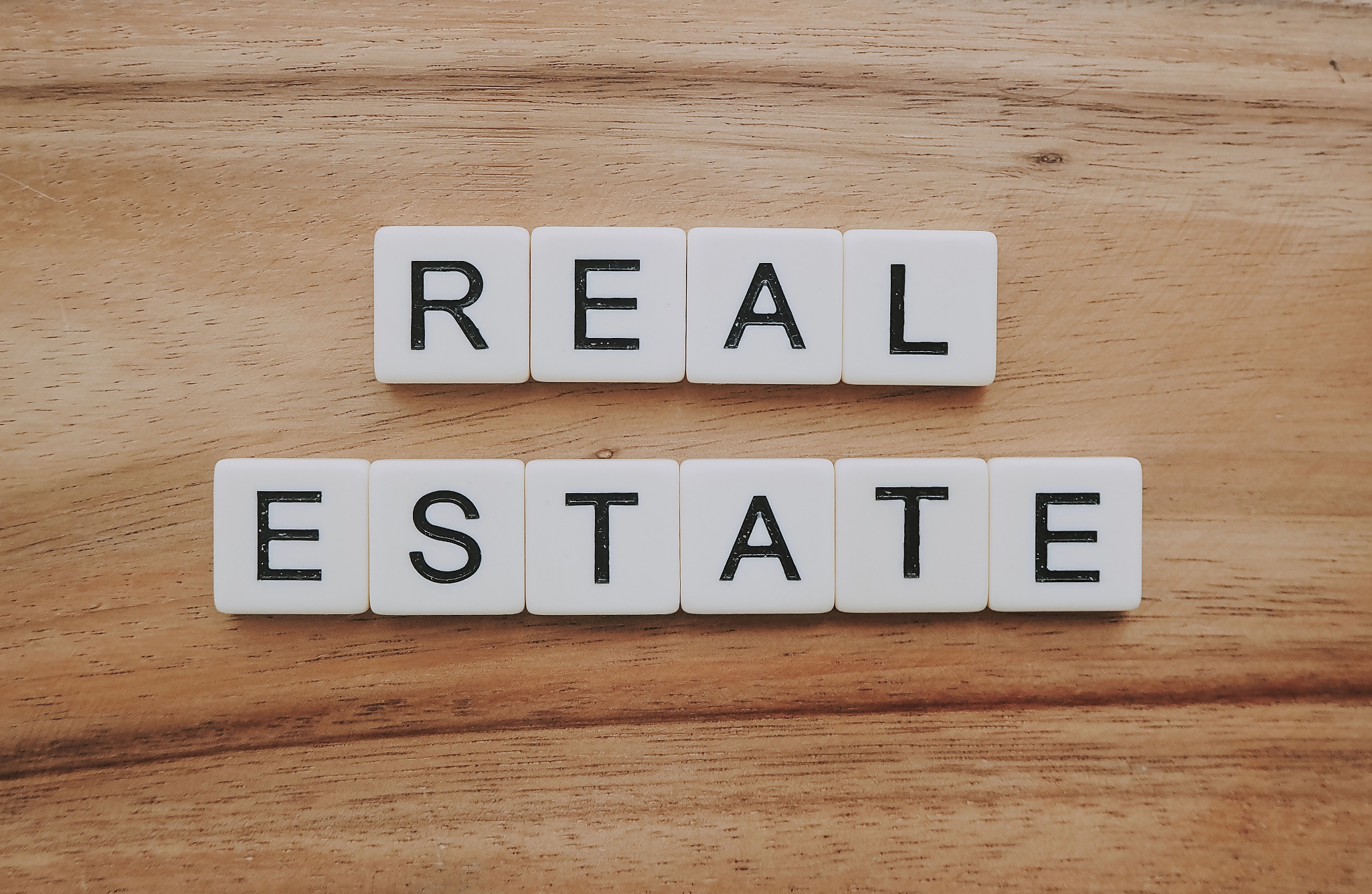 scrabble letters spelling out real estate