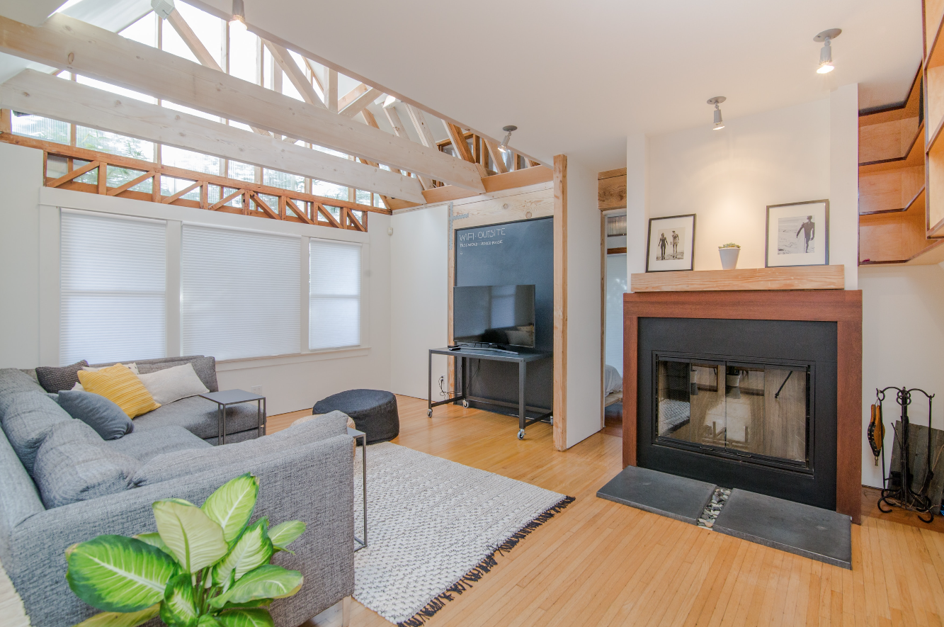 living room showing fireplace, vaulted ceilings and couch with rug
