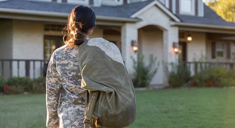 soldier walking toward a home