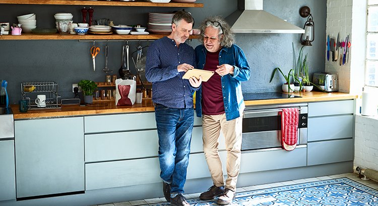 photo of two people standing in a kitchen look at a file