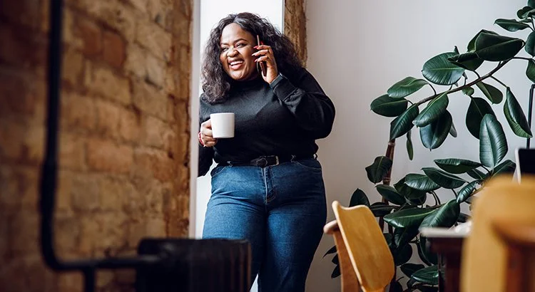 woman talking on phone while drinking coffee