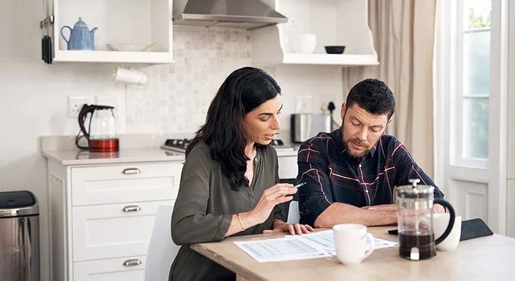 two people looking at charts at a kitchen table