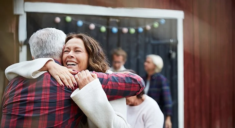 young woman hugging an older man possible his daughter
