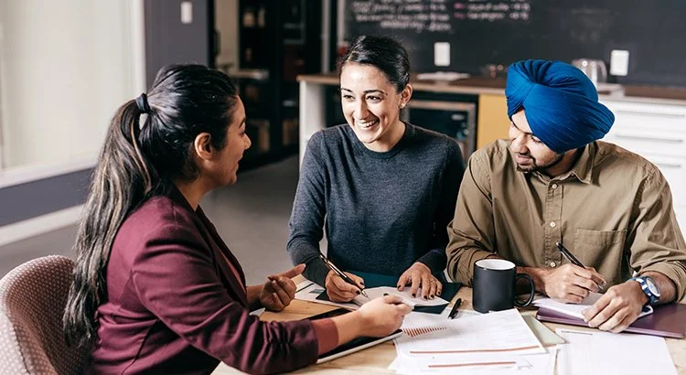 couple meeting with realtor at desk with papers