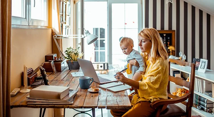 Oman with child looking at computer at table