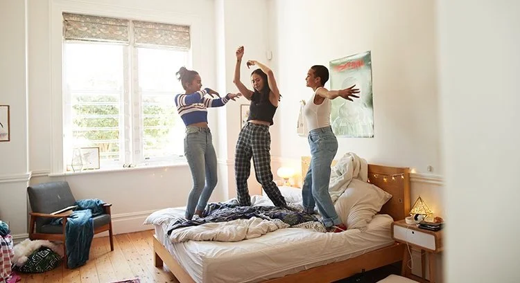 group of gen y home buyers jumping on bed