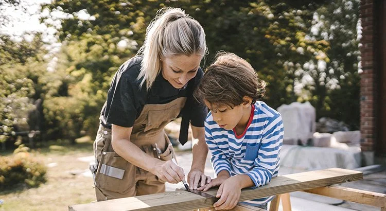 woman and boy measuring a piece of lumbar