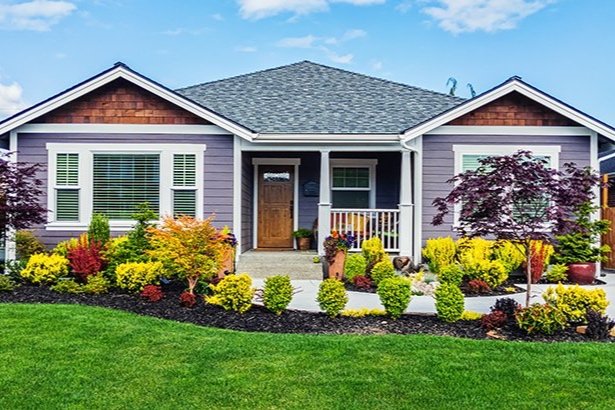 exterior of home with driveway surrounded by landscaping